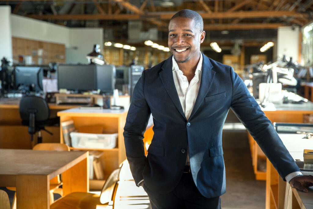 Black entrepreneur standing confidently in a modern office, representing black-owned franchises and business ownership