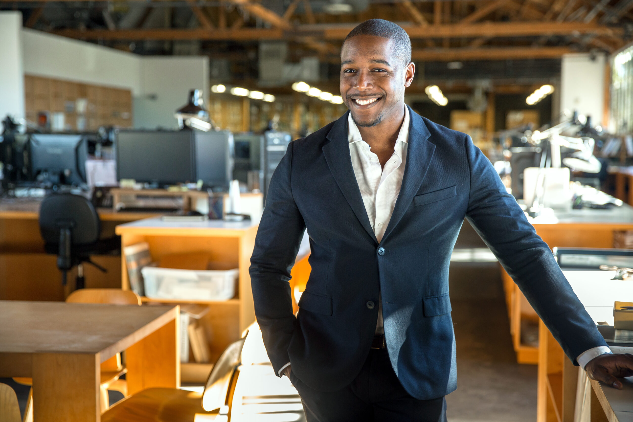 Black entrepreneur standing confidently in a modern office, representing black-owned franchises and business ownership